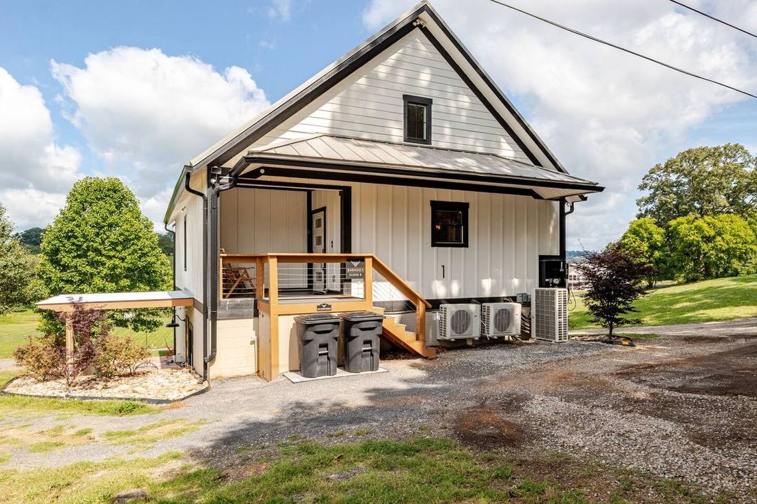 Rent every room under this roof — Barndo 1, our board-and-batten barndominium with its covered entry porch, at the fluffy cow farm near the Smoky Mountains.