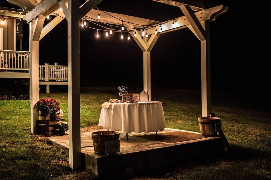 The Main Stage arbor glowing under string lights at night, curved steps leading up